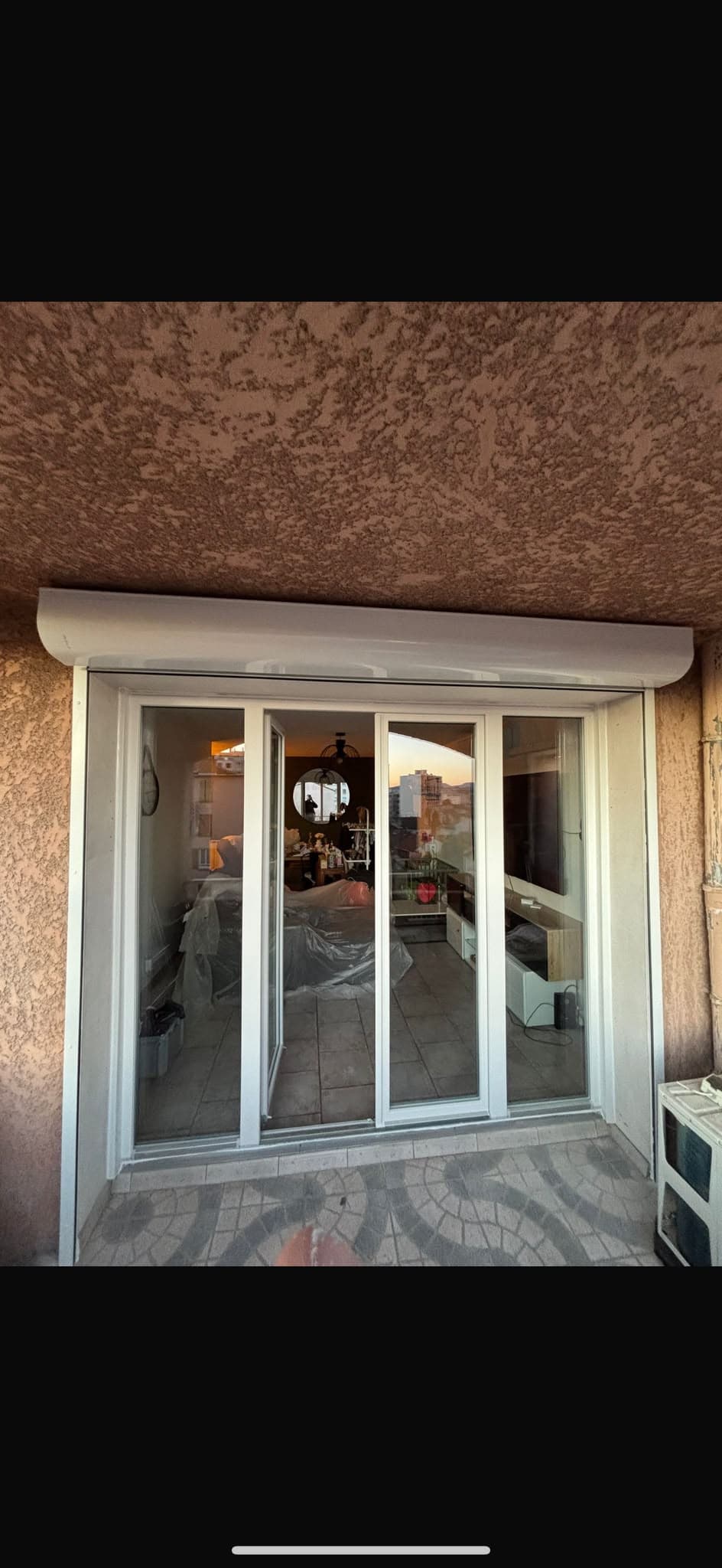 Baie coulissante aluminium blanc donnant sur une terrasse