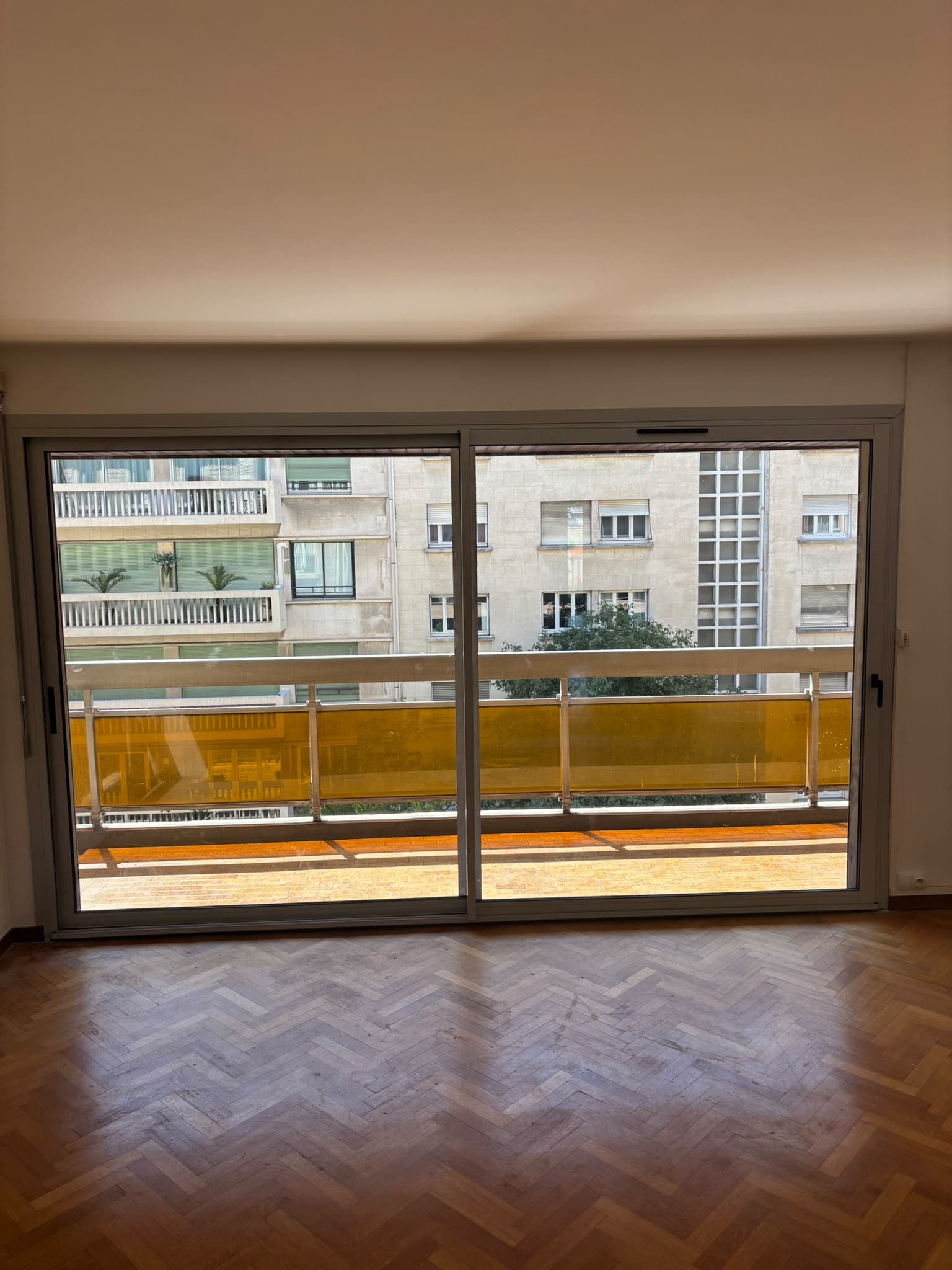 Baie coulissante aluminium gris avec parquet en chevron