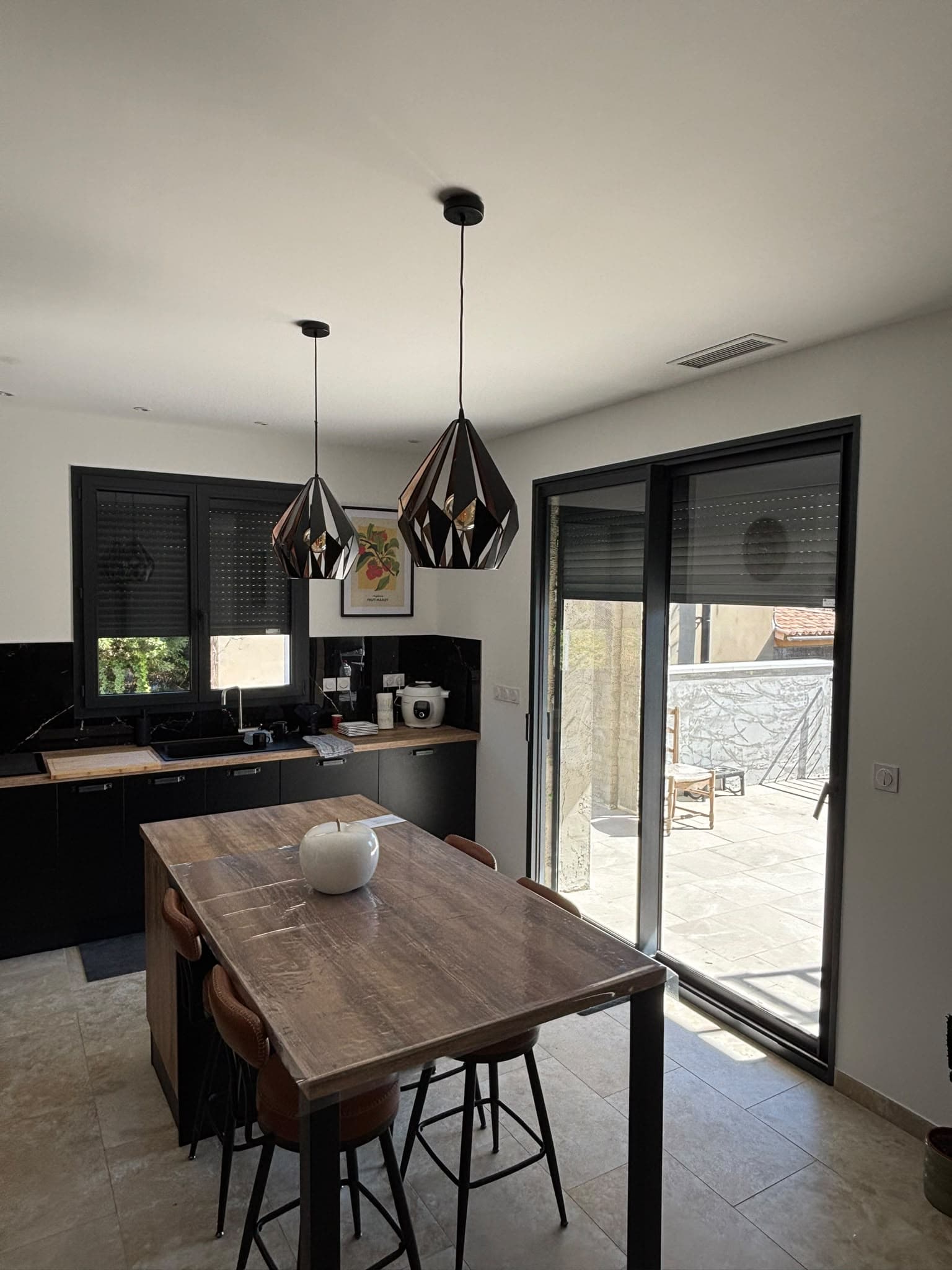 Baie vitrée coulissante aluminium noir posée par Afarnos Menuiserie dans une cuisine